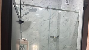 Un bagno con doccia vetrata, un water e un lavandino.