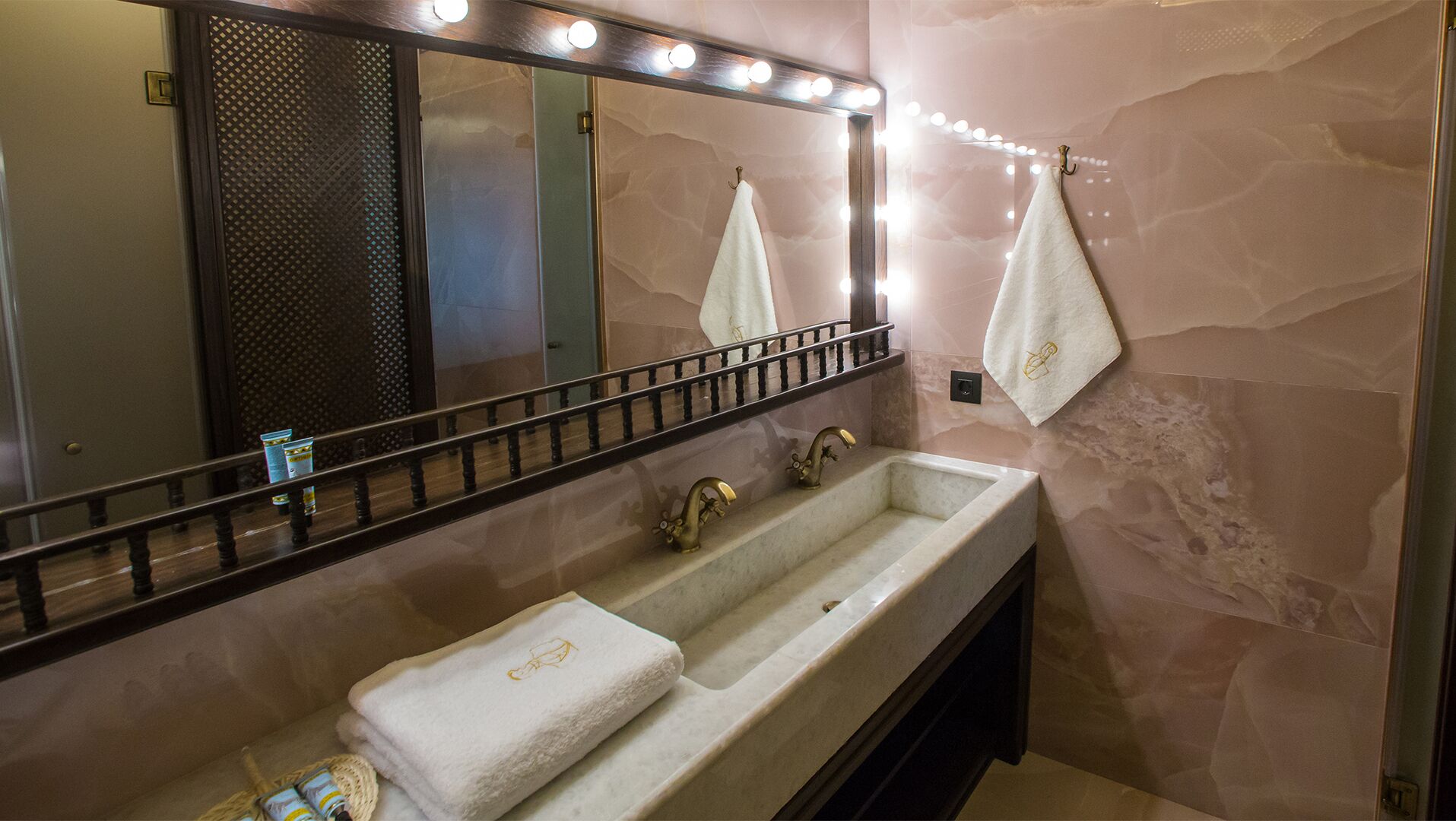 A bathroom with a large mirror, two sinks, and a vanity.