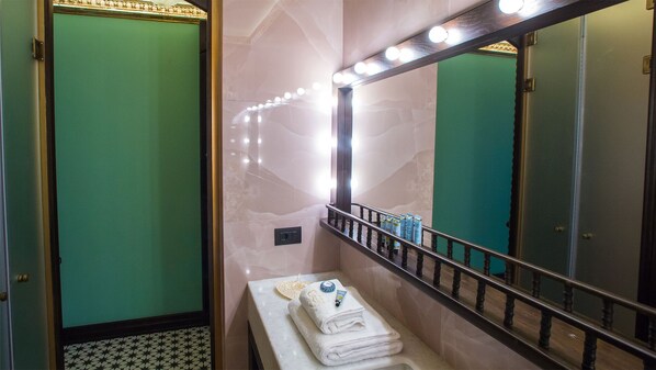 A bathroom with a vanity, a mirror with lights, and a towel rack. - Juan Rodriguez Hacienda (Athens)