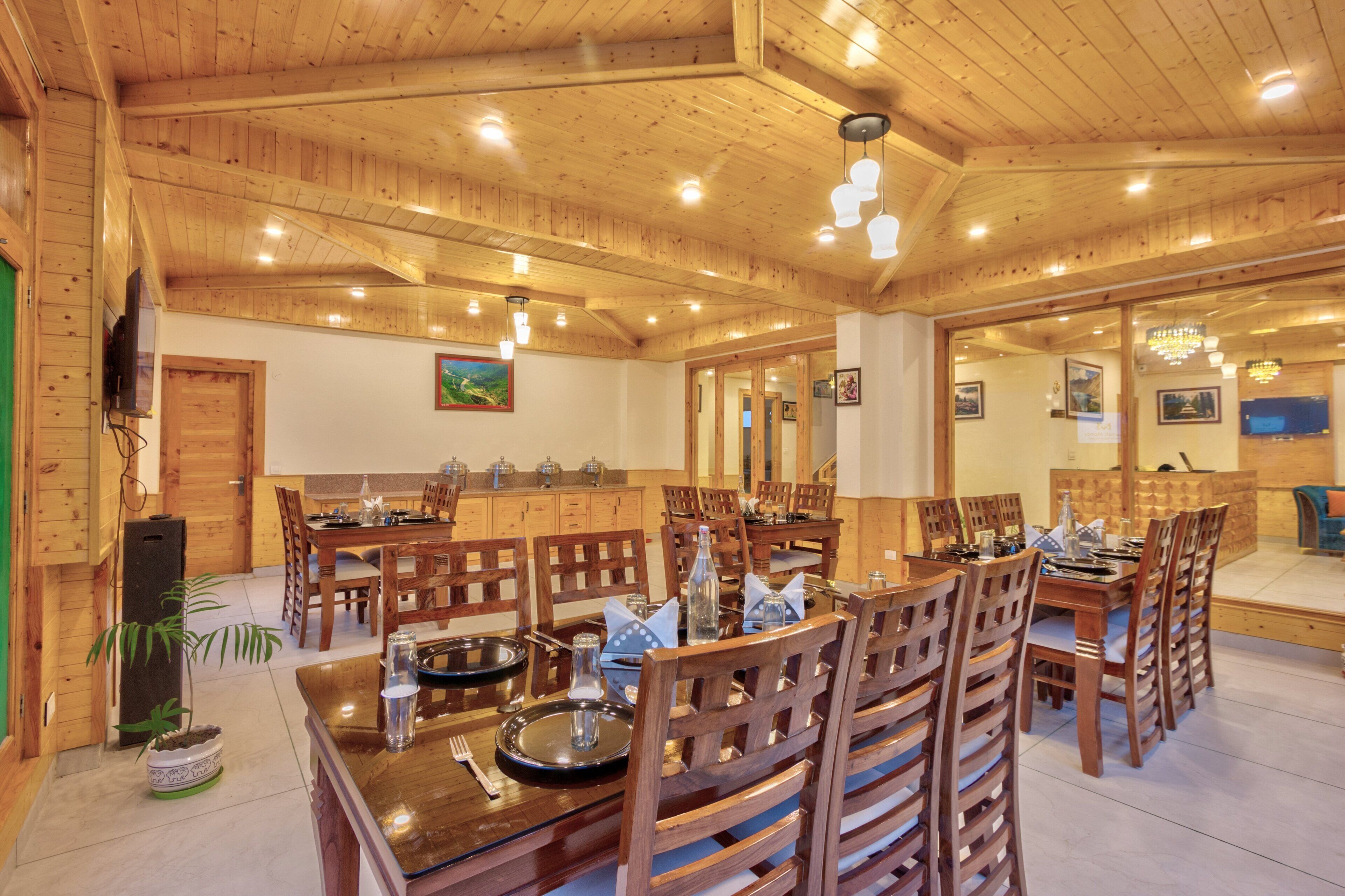 Un intérieur en bois comprenant un coin repas, un plafond en bois et un téléviseur fixé au mur.