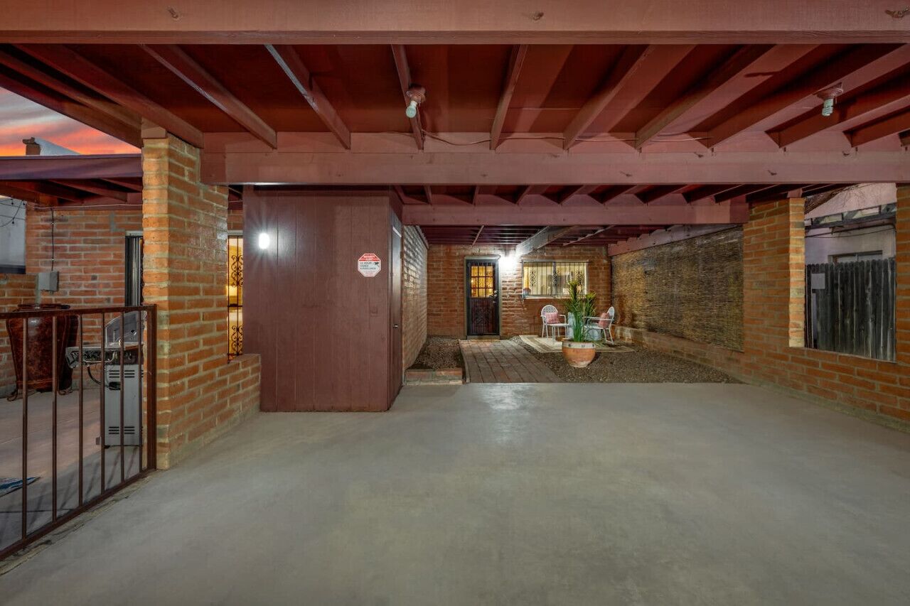 An indoor space with brick walls, a concrete floor, and a wooden door.