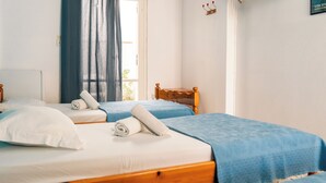 Een slaapkamer met twee bedden, een raam met gordijnen, een wandklok en een lijst met een afbeelding.