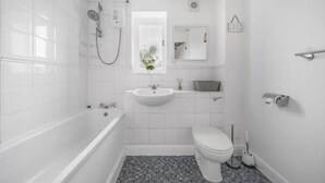 Ein Badezimmer mit Badewanne, Waschbecken, Toilette und Dusche.