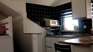A kitchen with black tiled backsplash, a microwave, and a sink. - ChezGyka Feel at Home! (Viseu)