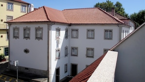 A white building with a red-tiled roof and multiple windows. - ChezGyka Feel at Home! (Viseu)
