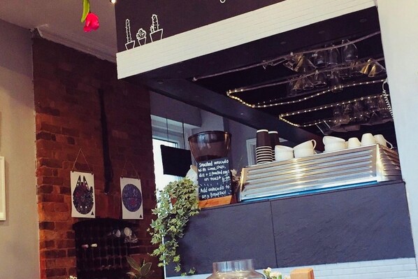 A restaurant interior with a brick wall, a chalkboard menu, and a variety of dishes and utensils on display. - Caravan-blackpool-familyfriendly-activities (Fleetwood)