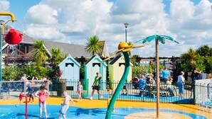 A water park with play structures, a pool, and a fenced area. - Caravan-blackpool-familyfriendly-activities (Fleetwood)