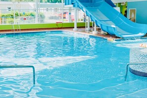 A swimming pool with a blue slide and clear water. - Caravan-blackpool-familyfriendly-activities (Fleetwood)