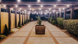 A covered walkway with evenly spaced lights, a central planter, and a row of wooden fences on one side. - Caravan-blackpool-familyfriendly-activities (Fleetwood)