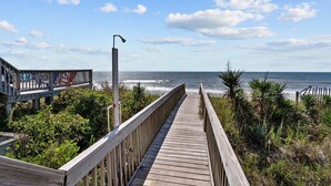 A wooden boardwalk leading to the beach with a clear view of the ocean. - Hana Kai #173 - Oceanfront Home in the Heart of Surf City! (Surf City)
