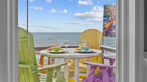 A table set for two with a view of the ocean. - Hana Kai #173 - Oceanfront Home in the Heart of Surf City! (Surf City)
