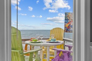 A table set for two with a view of the ocean. - Hana Kai #173 - Oceanfront Home in the Heart of Surf City! (Surf City)