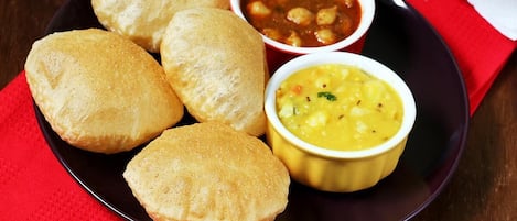 Un plato con cuatro bollos y dos tazones de sopa.