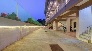 A covered walkway leading to a building with multiple floors and balconies. - Hotel Padmavati Palace Mahabaleshwar (Mahabaleshwar)
