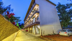 A multi-story building with a flat roof, balconies, and a parking area. - Hotel Padmavati Palace Mahabaleshwar (Mahabaleshwar)