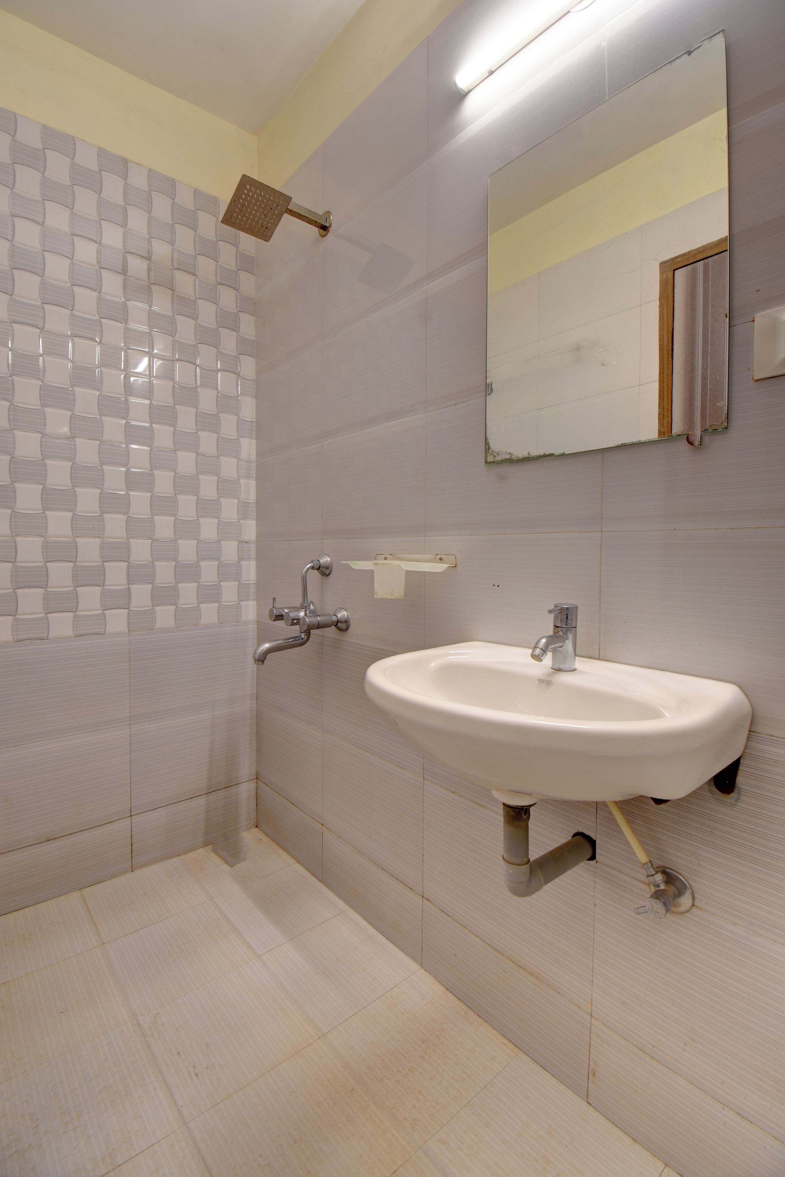 A bathroom with a shower, sink, and mirror.