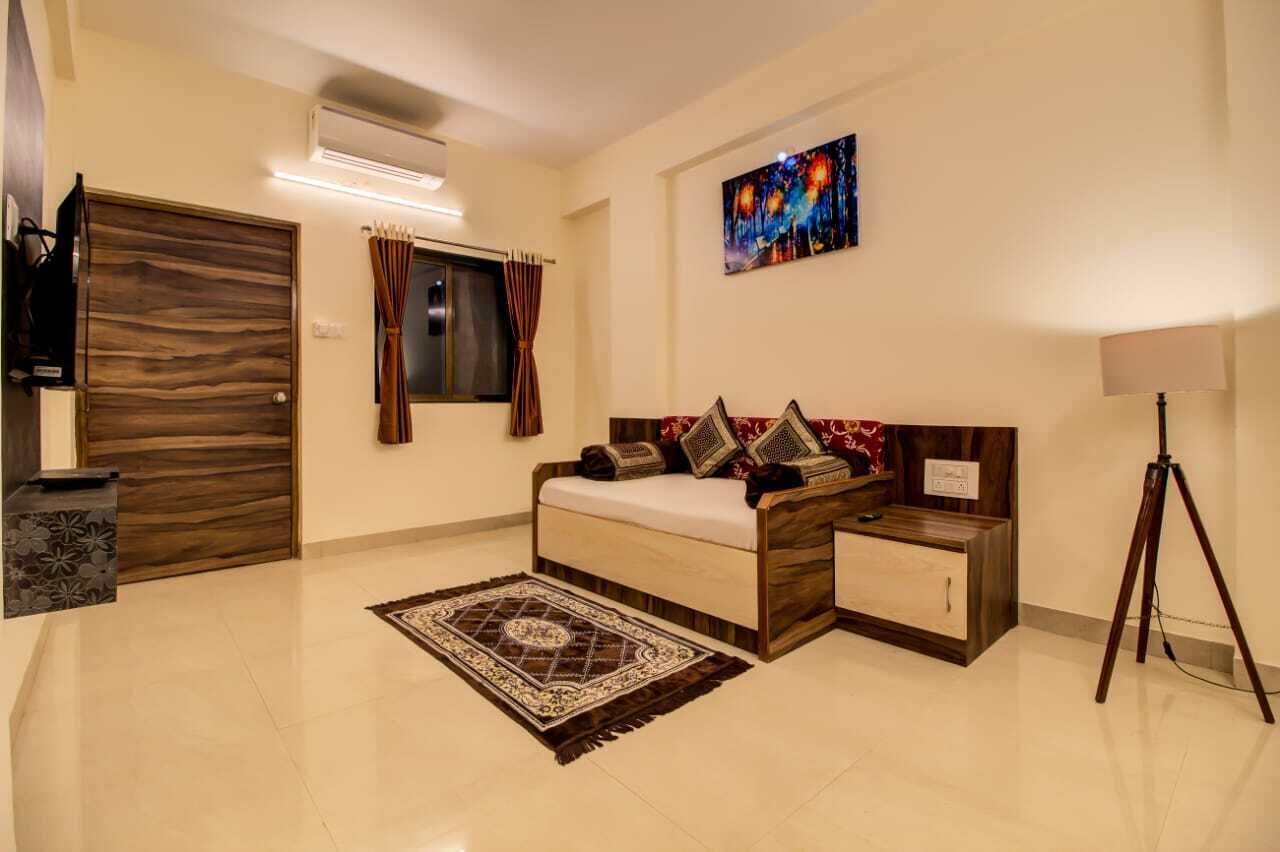 A bedroom with a bed, nightstands, a lamp, a TV, and a painting on the wall.