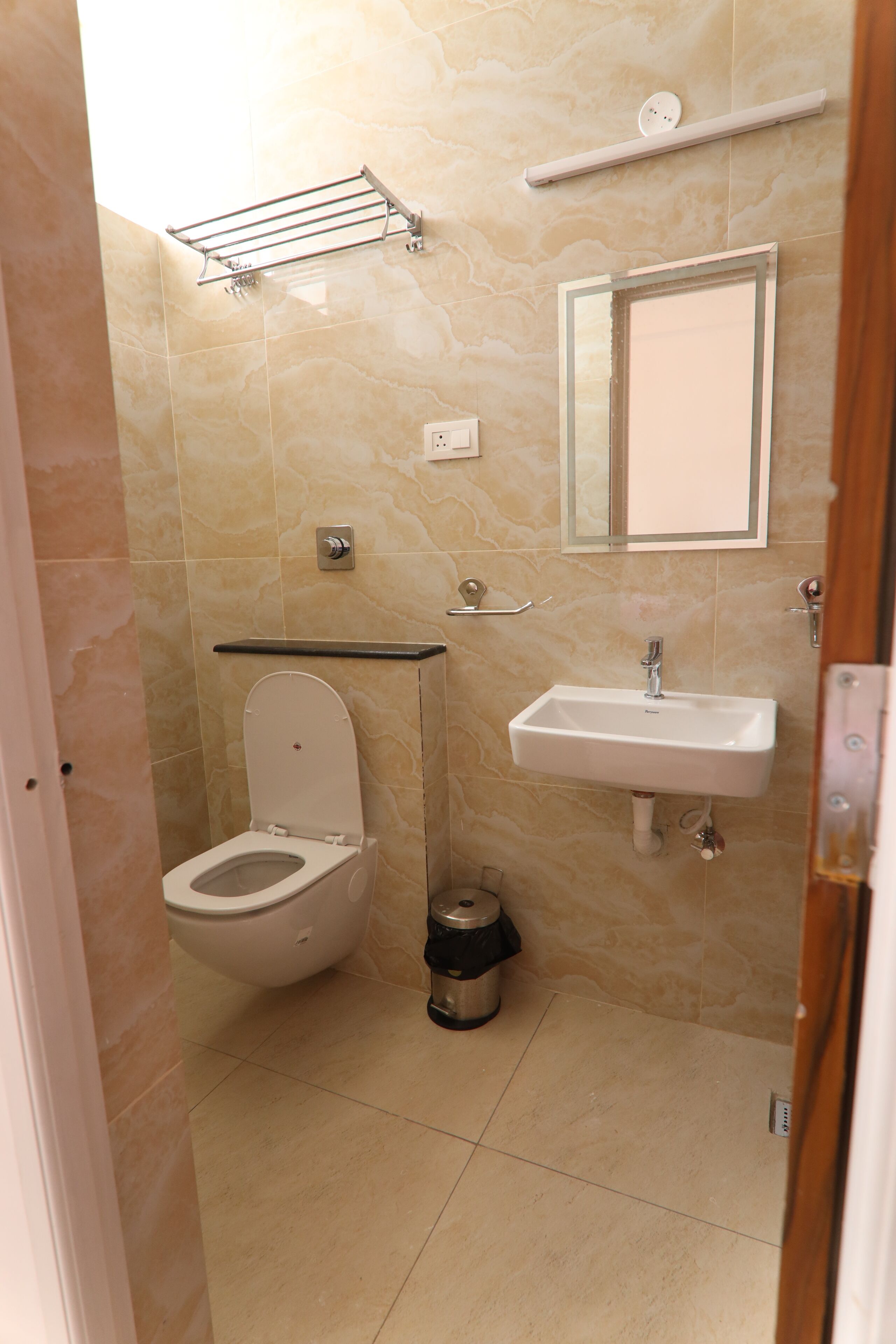A small bathroom with a toilet, sink, and mirror.