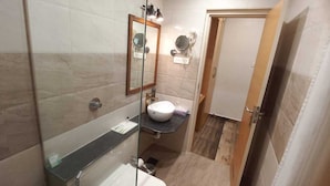A compact bathroom with a toilet, a sink, and a mirror. - Hotel Park Square  (Purnia)
