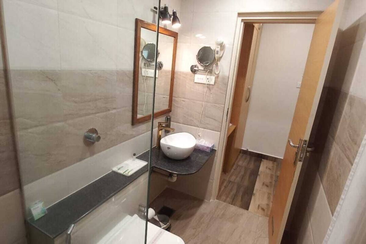A compact bathroom with a toilet, a sink, and a mirror.