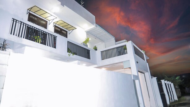 A modern white building with multiple balconies and a large glass window. - Zara Home (Galle)