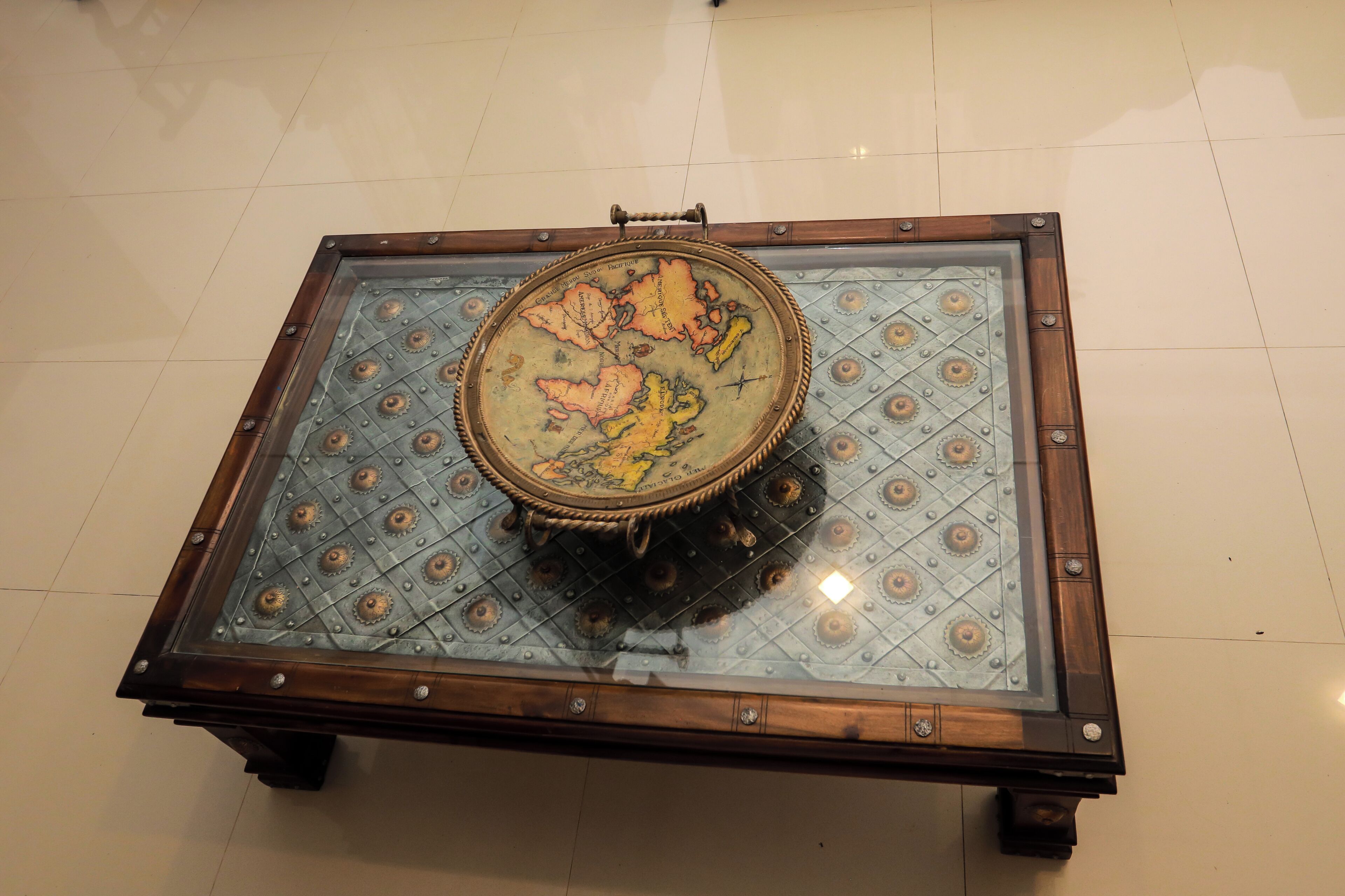 Una mesa cuadrada con cubierta de vidrio y diseño de mapa.
