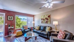 A modern living room with a glass coffee table, leather sofas, and a ceiling fan. - Breathtaking views of the Catalina and Rincon Mountains in this 2nd floor (Tucson)