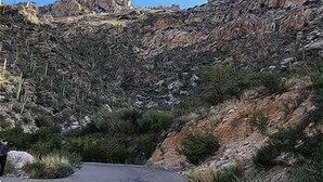 A narrow road flanked by rocky terrain and sparse vegetation. - Breathtaking views of the Catalina and Rincon Mountains in this 2nd floor (Tucson)