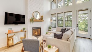 Un salón amplio con chimenea, un televisor de pantalla plana grande y una zona de estar acogedora.
