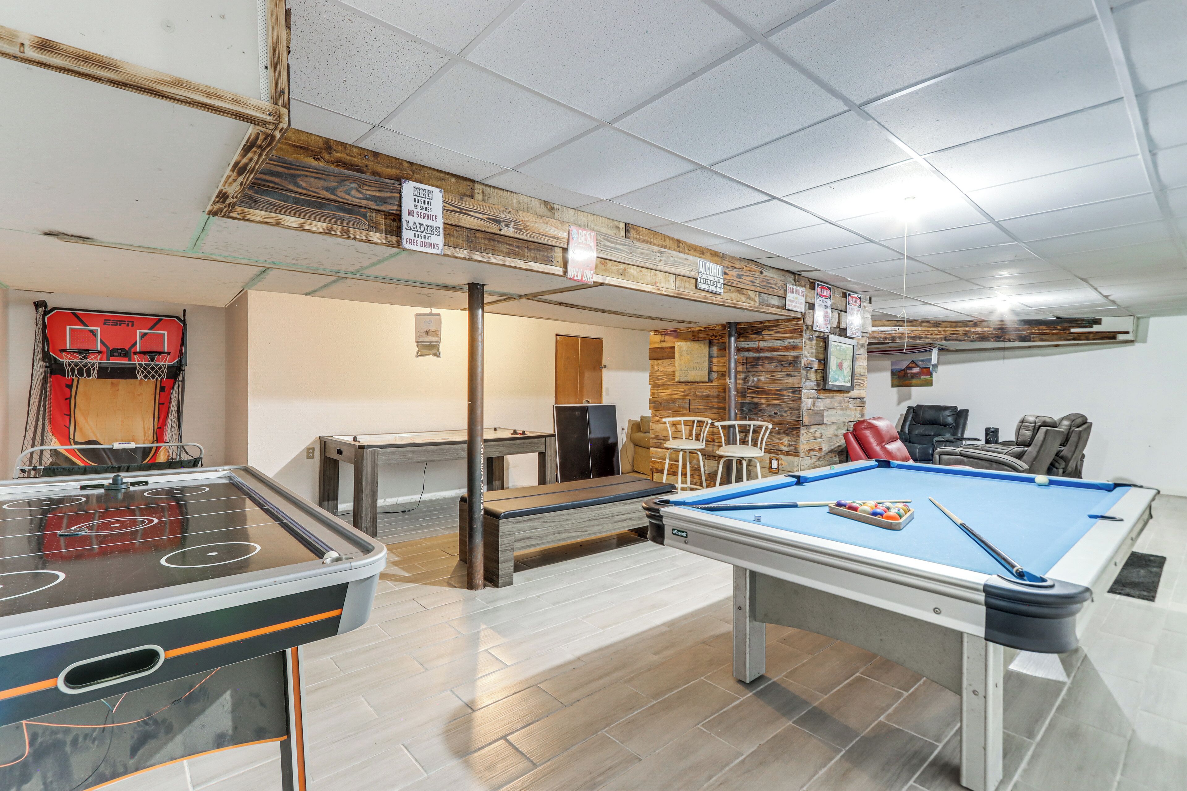 Un espace de loisirs équipé d’une table de billard, d’un baby-foot et d’un panier de basket.