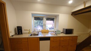 Una cocina compacta equipada con lavavajillas, cafetera, tostadora y microondas.