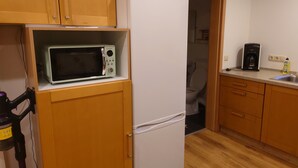 Una cocina compacta equipada con microondas, refrigerador y cafetera.