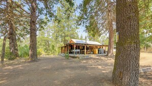 A rustic cabin with a porch, surrounded by tall trees. - Rustic Cabin w/ Patio: 8 Mi to Kings Canyon Park (Miramonte)
