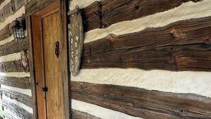 A wooden log cabin with a bench and a welcome mat. - Log cabin with mountain VIEWS in Lexington! Near VA Horse Ctr, 8 mi from VMI/W&L (Lexington)
