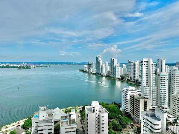 A high-rise urban area with a river, modern buildings, and a clear sky.