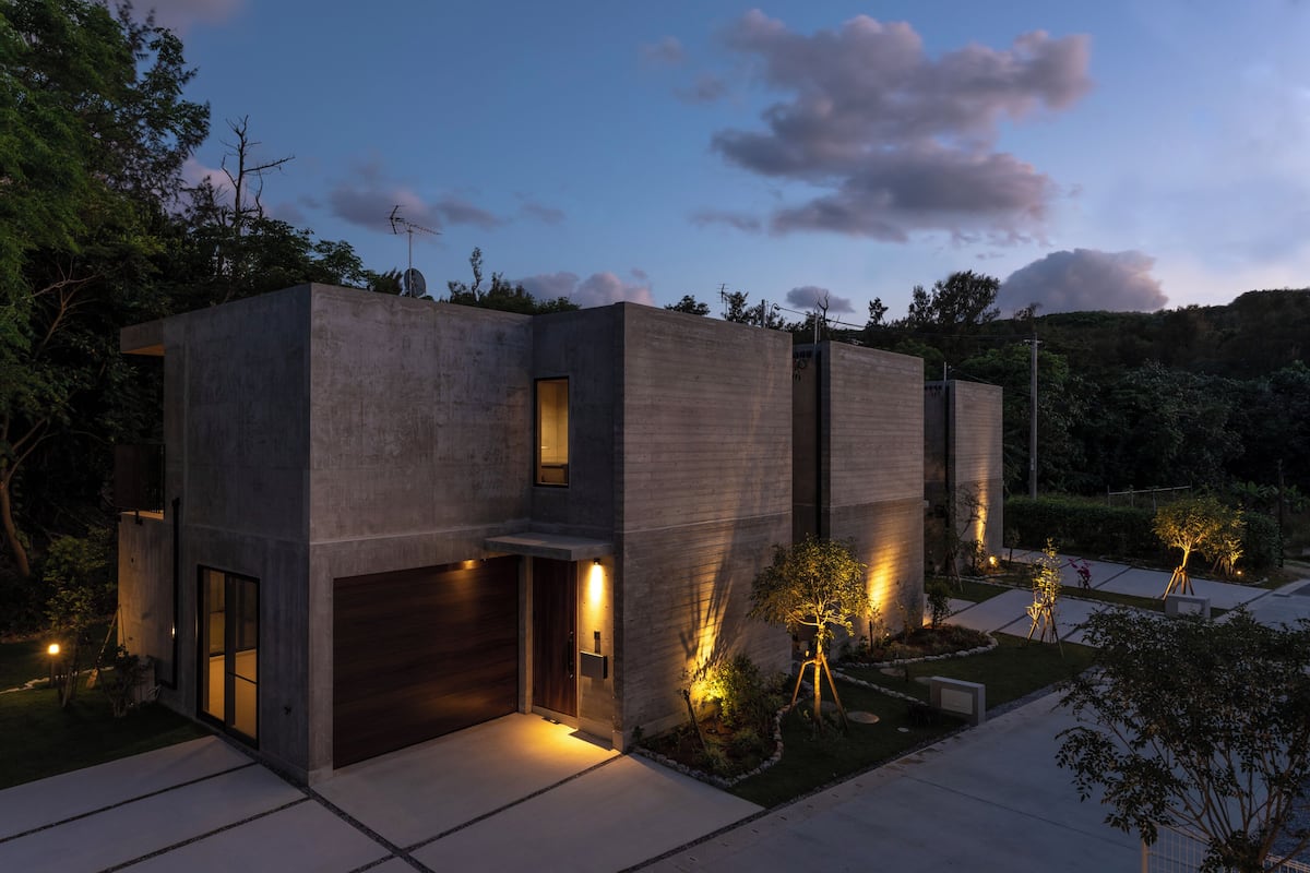 A modern house with a garage, a well-lit entrance, and a landscaped garden.