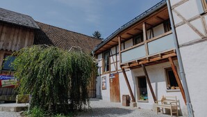 A traditional building with a wooden facade, a tiled roof, and a signboard. - Vacation apartment Linda (Ilmenau)