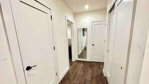 A hallway with white doors and wooden flooring. - Prime soho 2 bedroom (New York)