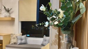 Taula de fusta amb un ram de flors blanques, una espelma i un objecte decoratiu.