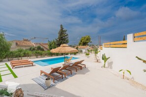 A pool area with lounge chairs, a table, and a thatched umbrella. - CostaBlancaDreams - Las Mariposas in Benissa (Benissa)