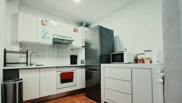 stovetop, refrigerator, microwave, kitchen visible, daytime
