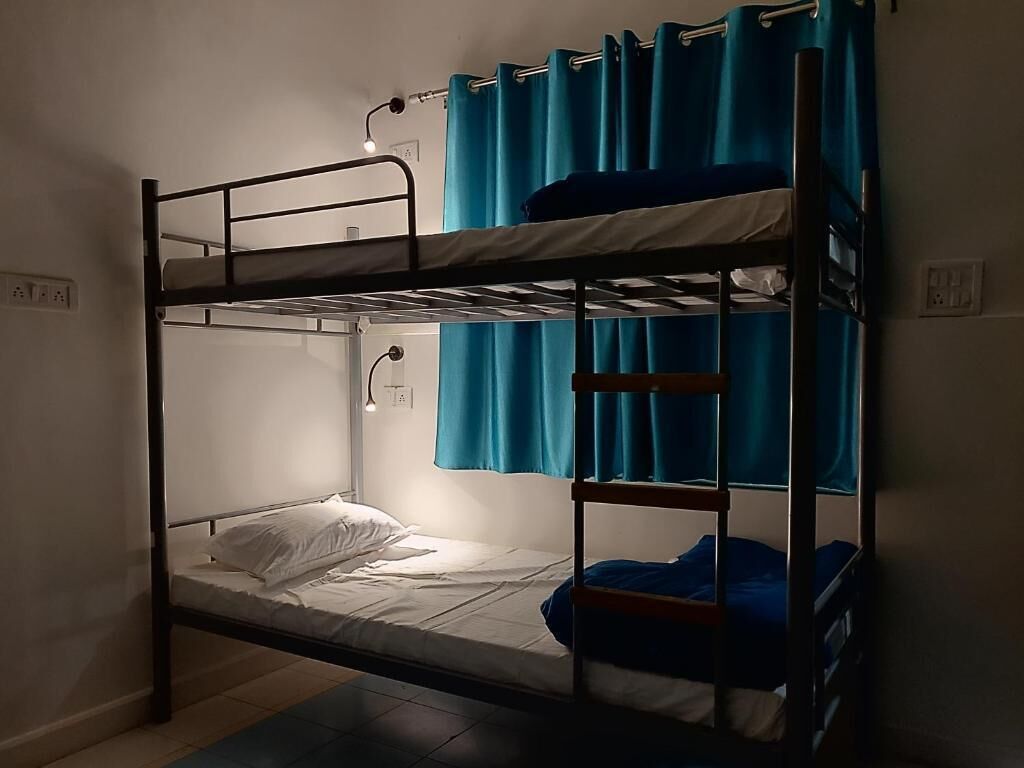 A bunk bed with a single mattress and a pull-out bed on the upper bunk.