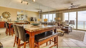 Un salon spacieux avec une grande table à manger, des sièges confortables et un balcon offrant une vue agréable.