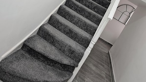 Eine Treppe mit Teppichstufen, die zu einer Zwischenebene führt.