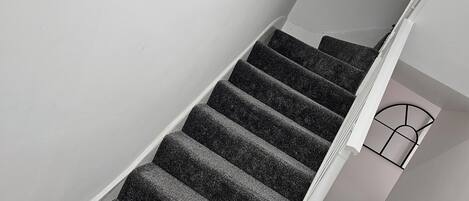Una escalera con peldaños alfombrados que conduce a una plataforma.