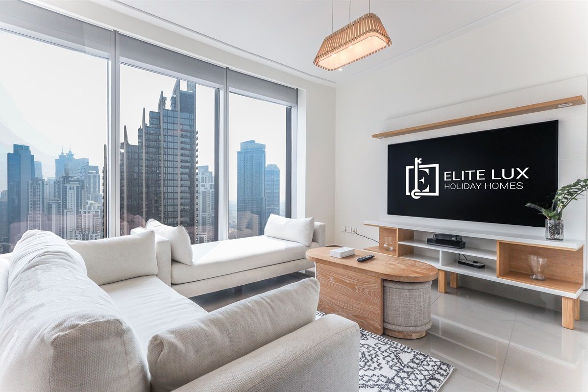 A modern living room with a large window, a sofa, a TV, and a city view.