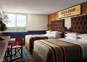 A hotel room with two beds, a desk, a chair, and a large window offering a view of the outdoors.