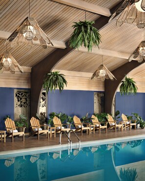 A poolside area with wooden chairs and hanging wicker lamps.