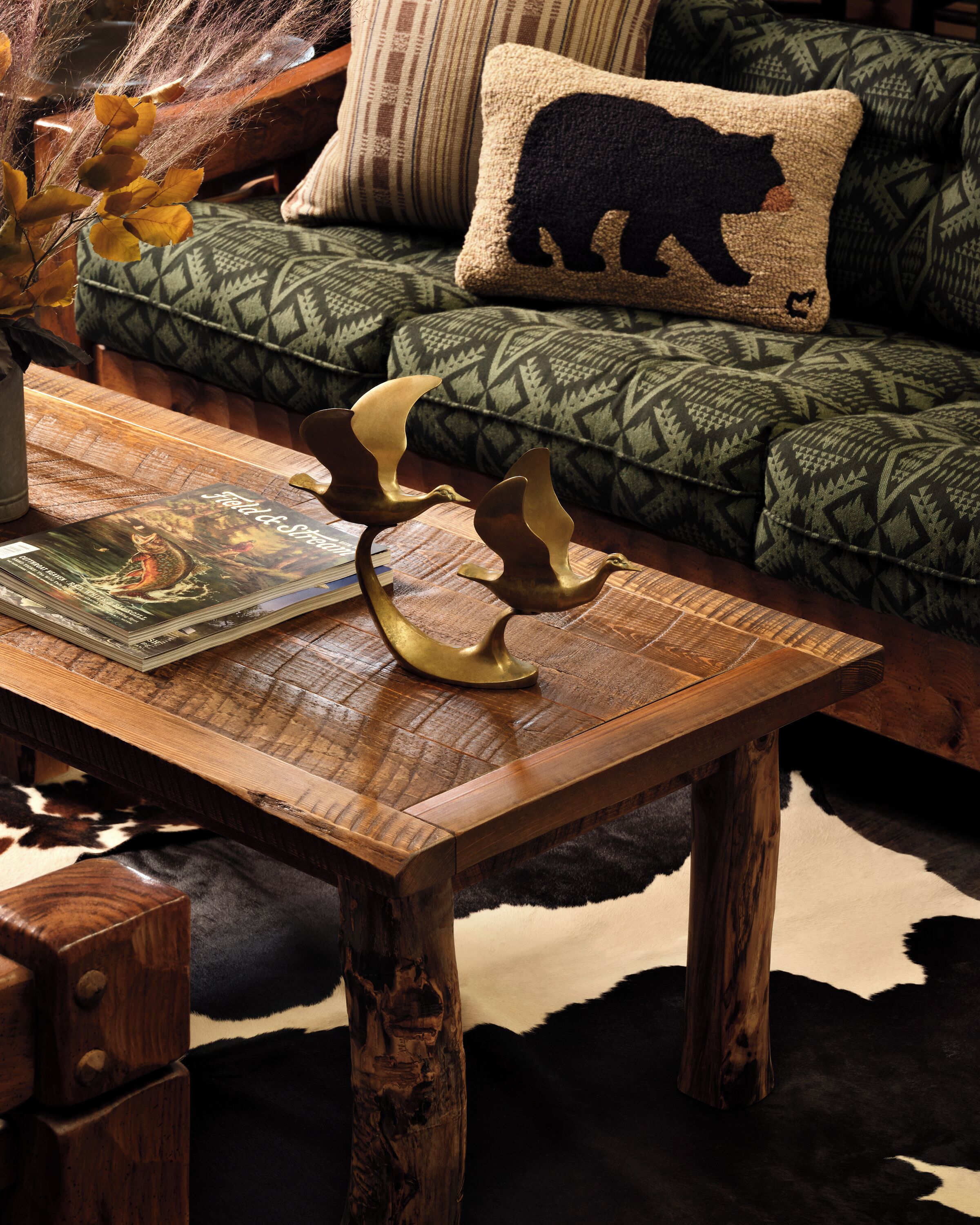 Une table basse en bois, sur laquelle sont posés un livre et des sculptures d’oiseaux décoratives.