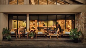 A modern building with a large glass facade, wooden interior seating, and a stone exterior wall. - Field & Stream Lodge Bozeman (Bozeman)